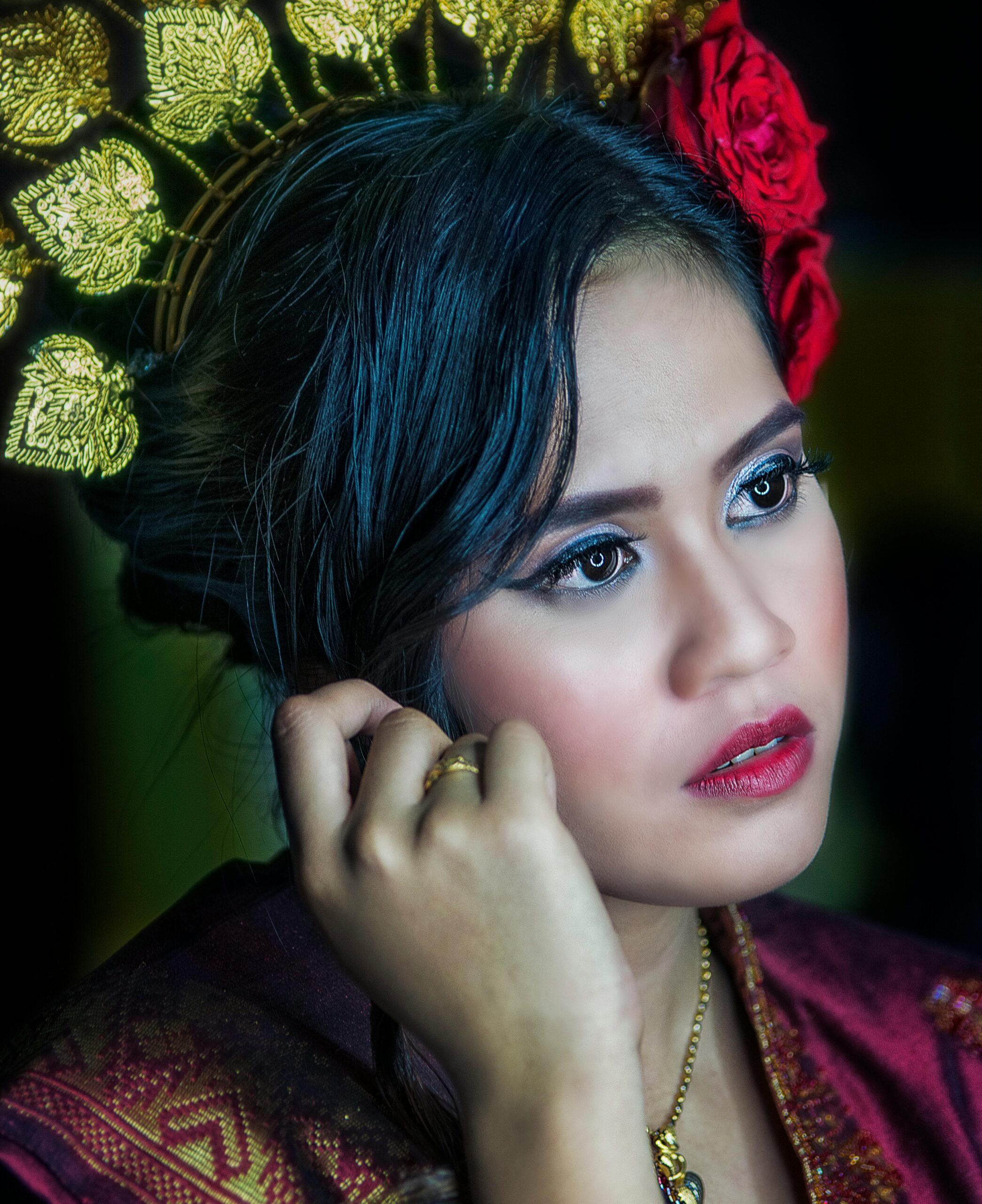 Close-up portrait of a beautiful Malaysian woman in traditional attire with intricate headpiece.